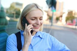 Kundin telefoniert unterwegs mit dem Smartphone